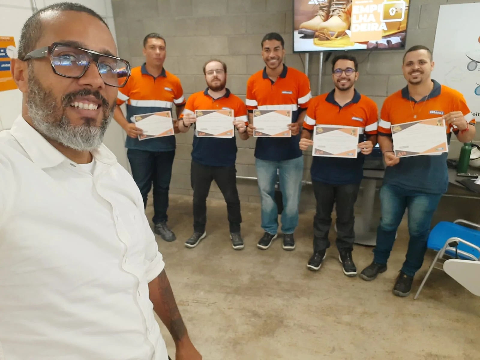 Turma de colaboradores com certificados após treinamento da JML